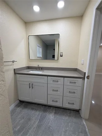 a bathroom with a granite countertop sink and a mirror
