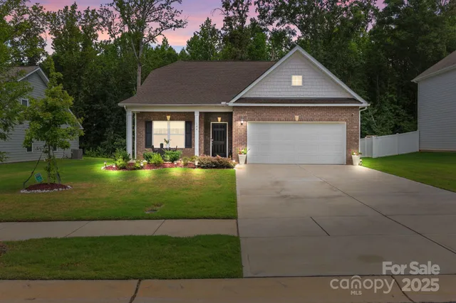 a front view of a house with a yard and trees