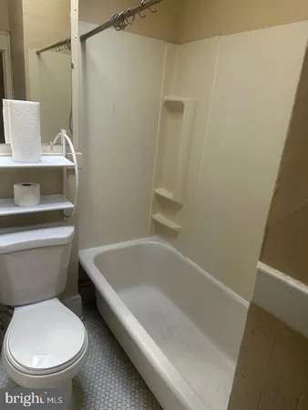 a white toilet sitting next to a bath tub
