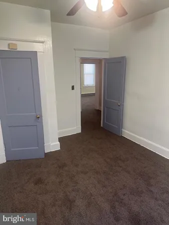 an empty room with closet and windows
