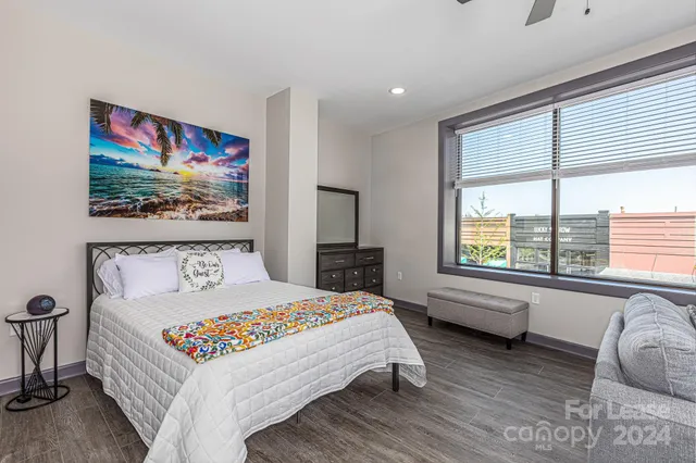 a bedroom with a bed and a large window