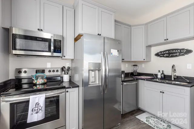 a kitchen with stainless steel appliances granite countertop a refrigerator a stove a sink and cabinets