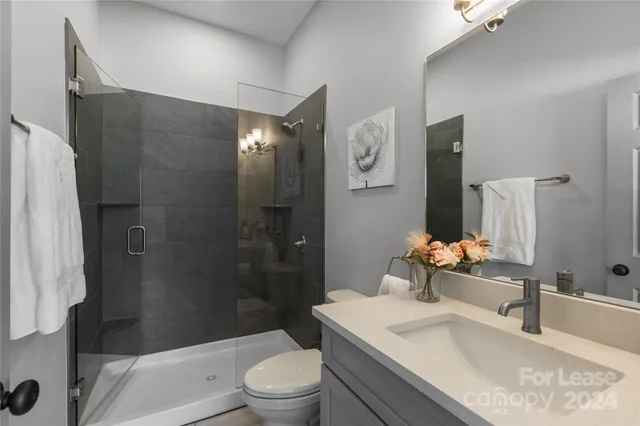 a bathroom with a granite countertop sink toilet and shower