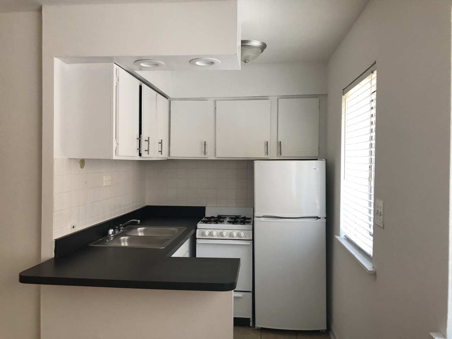 536 West Addison Street, Unit 391 Chicago, IL 60613 - Photo 2 of 6 a kitchen with a refrigerator and a stove