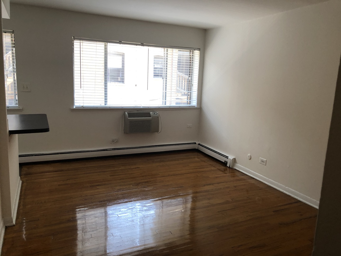 536 West Addison Street, Unit 391 Chicago, IL 60613 - Photo 3 of 6 a view of an empty room with wooden floor and a window