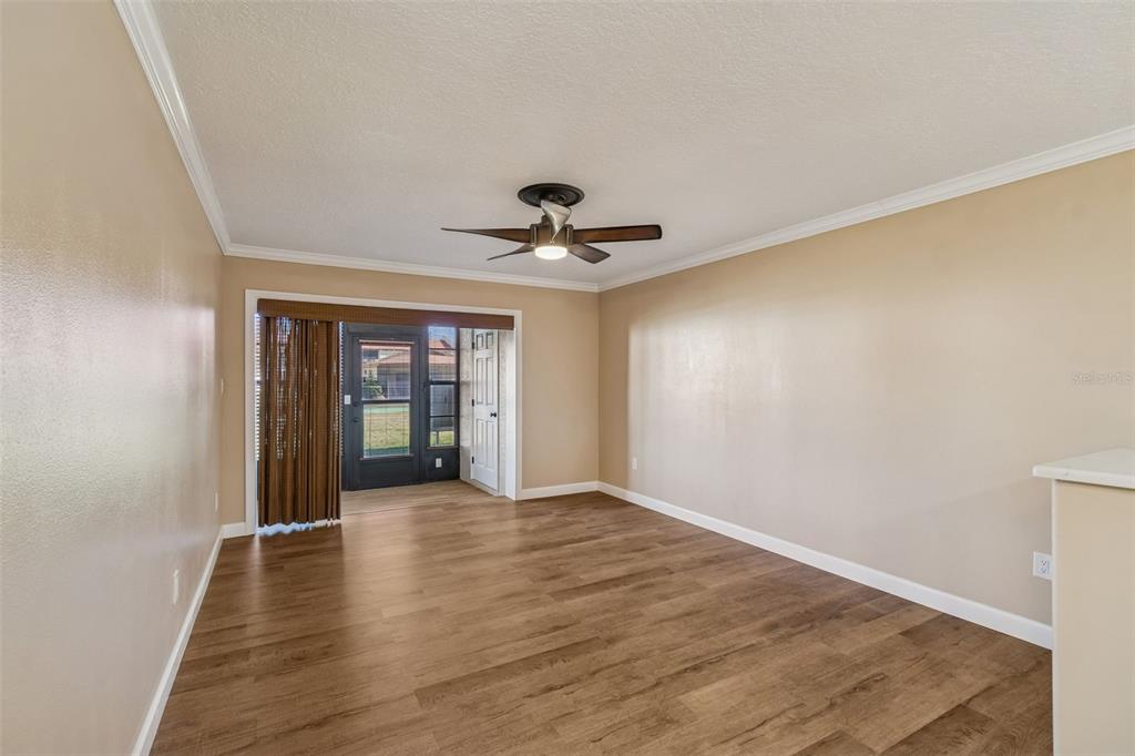 4937 Marine Parkway, Unit 105 New Port Richey, FL 34652 - Photo 13 of 50 a view of a room with wooden floor and a ceiling fan