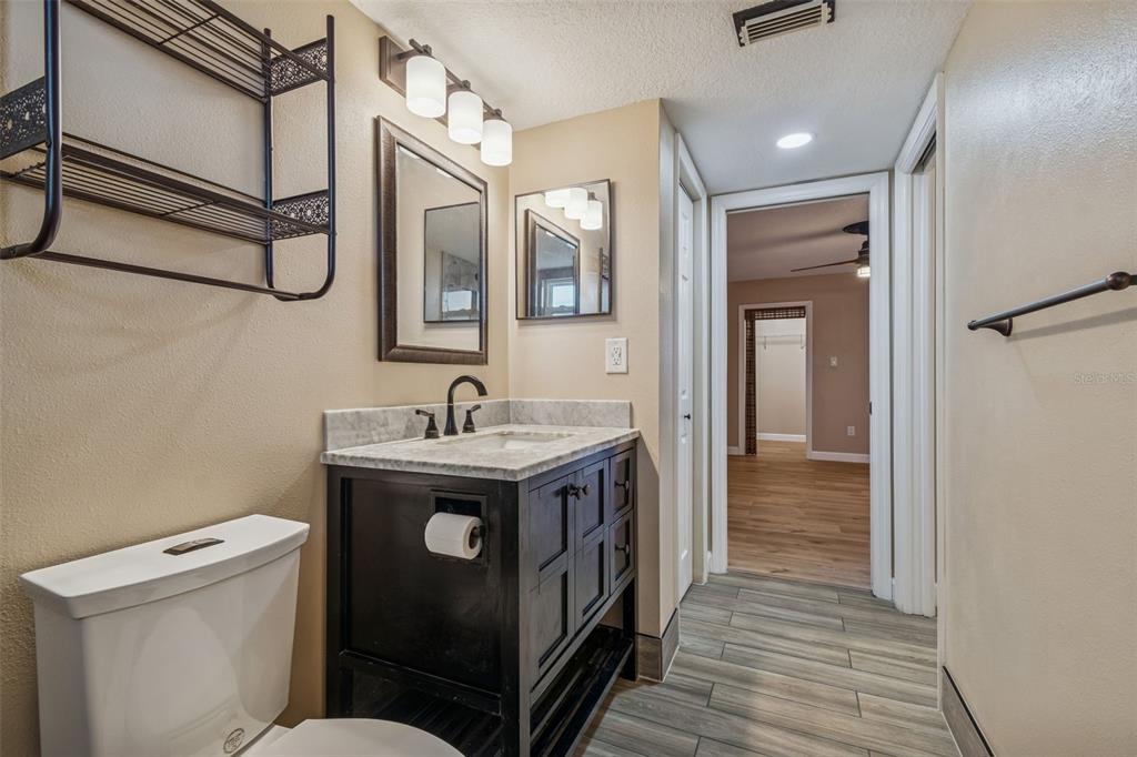 4937 Marine Parkway, Unit 105 New Port Richey, FL 34652 - Photo 19 of 50 a bathroom with a toilet sink and mirror