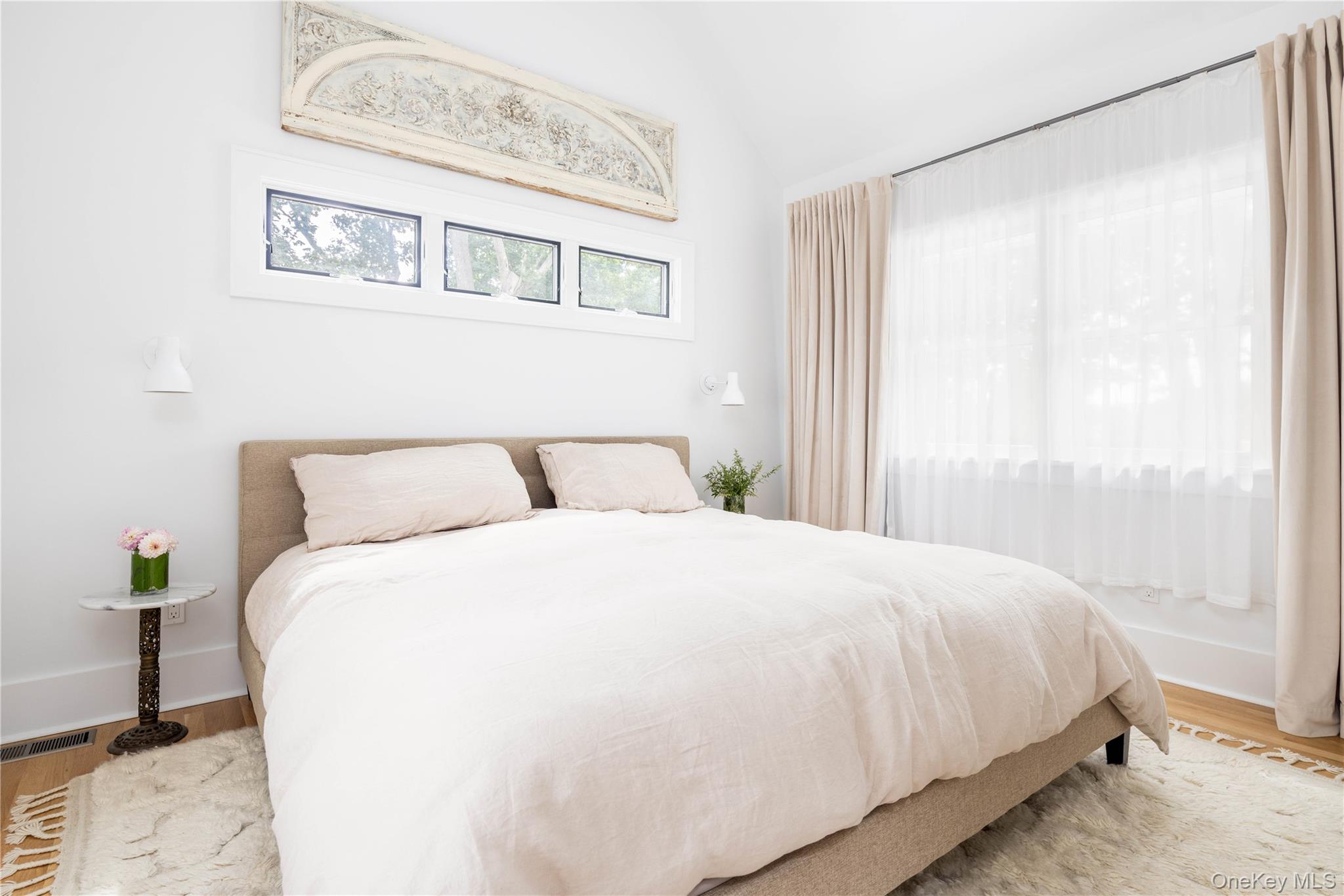 1260 Main Road Jamesport, NY 11901 - Photo 20 of 22 a large bed sitting in a bedroom next to a window