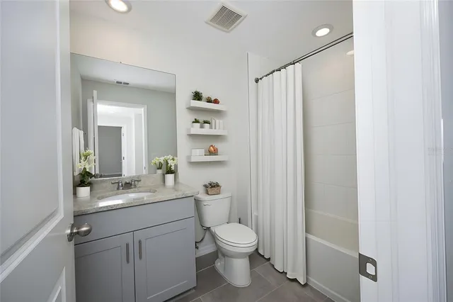 a bathroom with a granite countertop sink toilet a mirror and shower