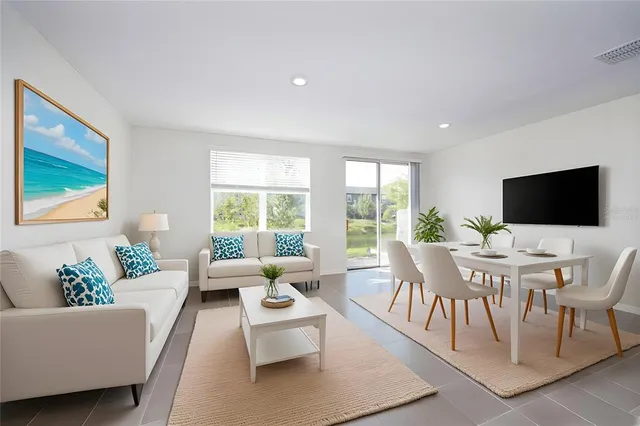 a living room with furniture a flat screen tv and a floor to ceiling window