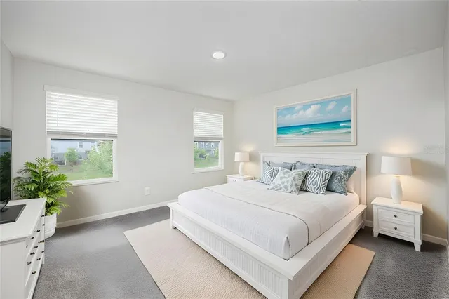 a bedroom with a large bed and a potted plant