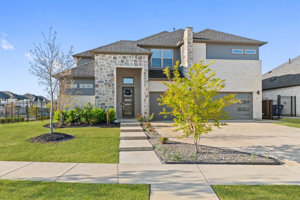 2677 Wiregrass Road Frisco, TX 75033 - Photo 1 of 40 View of front of property featuring a front yard, an attached garage, stone siding, fence, and concrete driveway