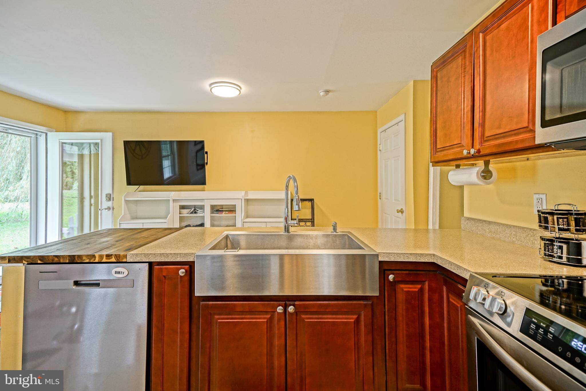 18897 Sand Hill Road Milton, DE 19968 - Photo 12 of 51 a kitchen with a sink a counter top space cabinets stainless steel appliances and a window
