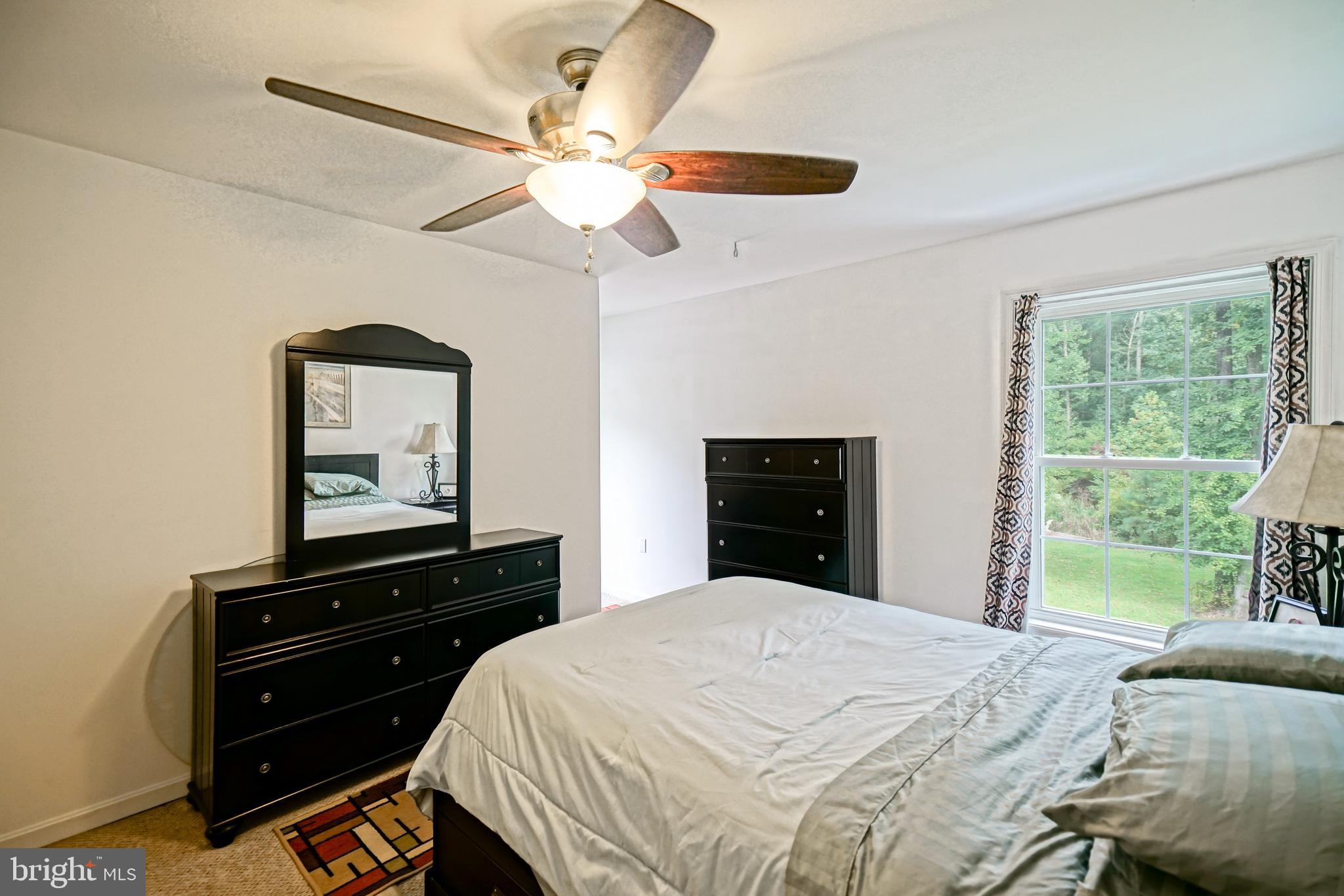 18897 Sand Hill Road Milton, DE 19968 - Photo 27 of 51 a bedroom with a bed and a dresser next to a window