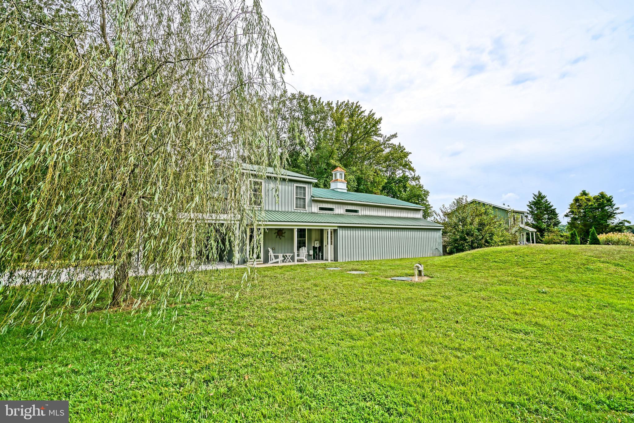 18897 Sand Hill Road Milton, DE 19968 - Photo 4 of 51 a house that has a big yard with large trees