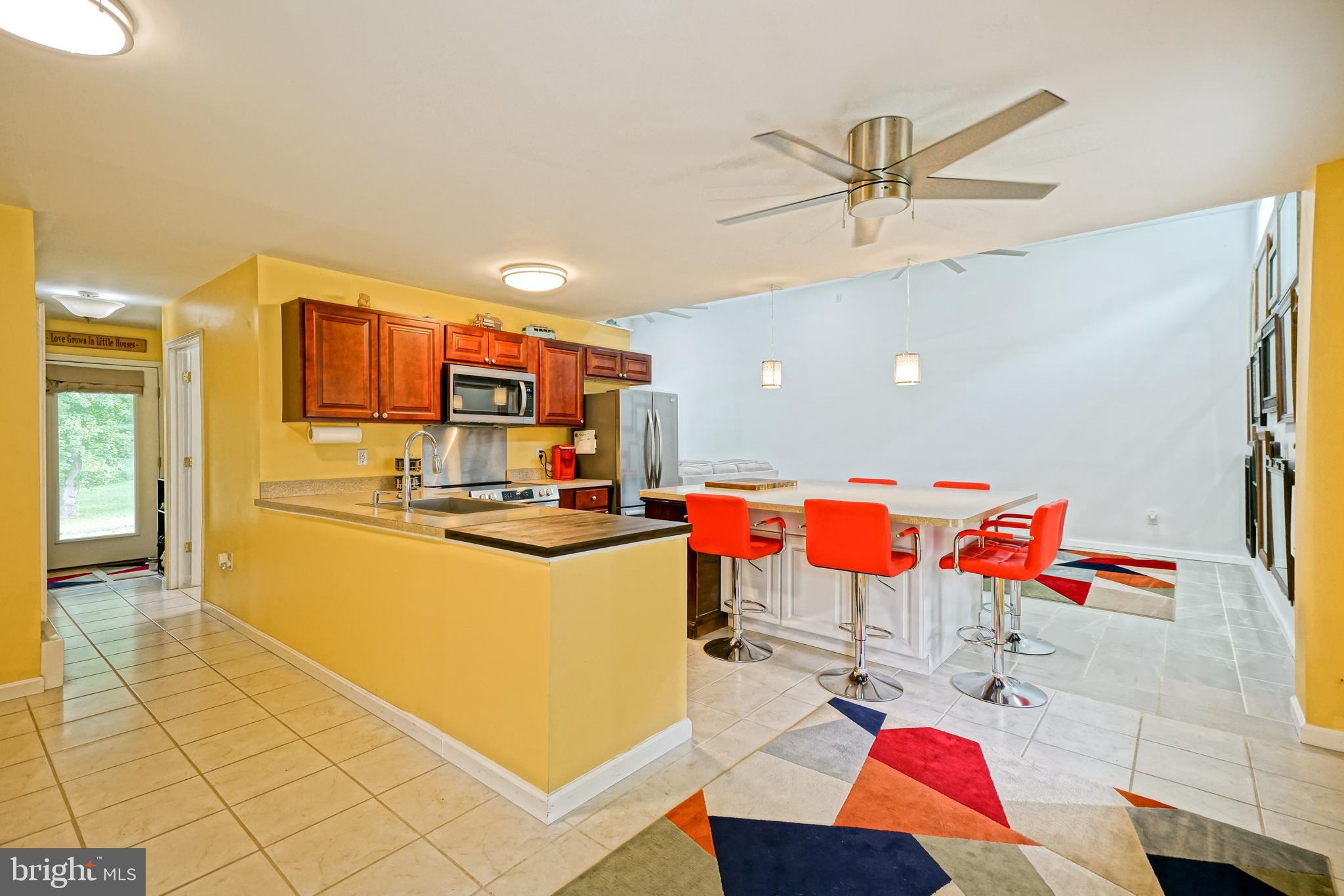 18897 Sand Hill Road Milton, DE 19968 - Photo 8 of 51 a living room with a kitchen island furniture and a ceiling fan