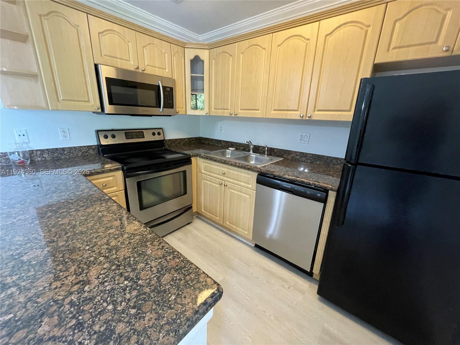 1401 Northeast 53rd Street, Unit 211 Fort Lauderdale, FL 33334 - Photo 1 of 14 a kitchen with granite countertop a refrigerator stove and microwave
