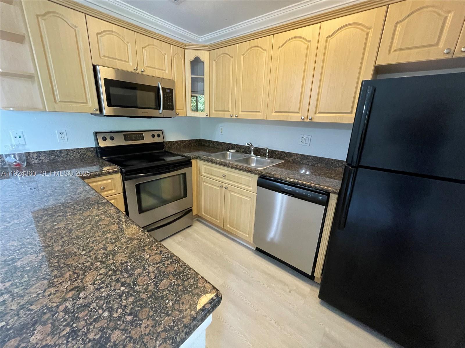 1401 Northeast 53rd Street, Unit 211 Fort Lauderdale, FL 33334 - Photo 3 of 14 a kitchen with a stove microwave and sink