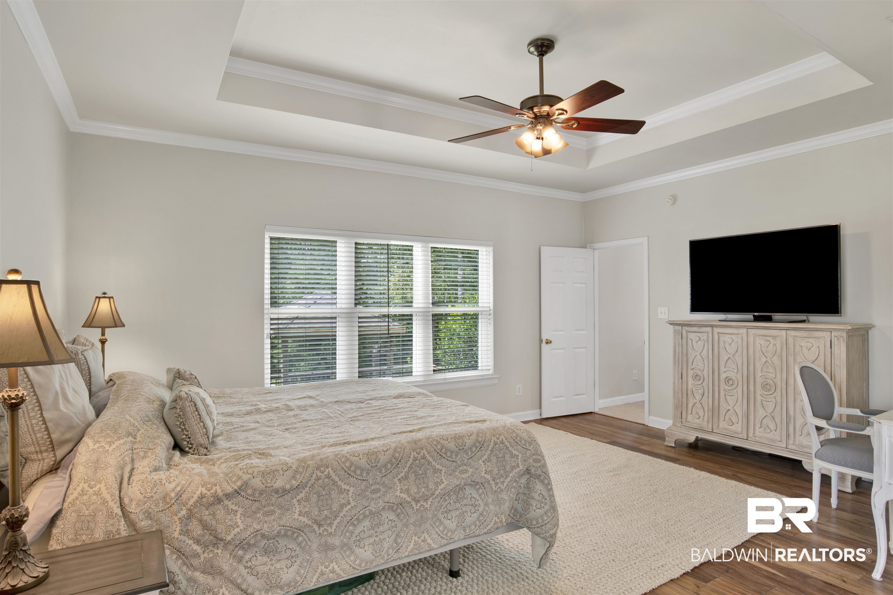 638 Southern Way Daphne, AL 36527 - Photo 13 of 26 Bedroom featuring ceiling fan, dark hardwood / wood-style floors, ornamental molding, and a tray ceiling