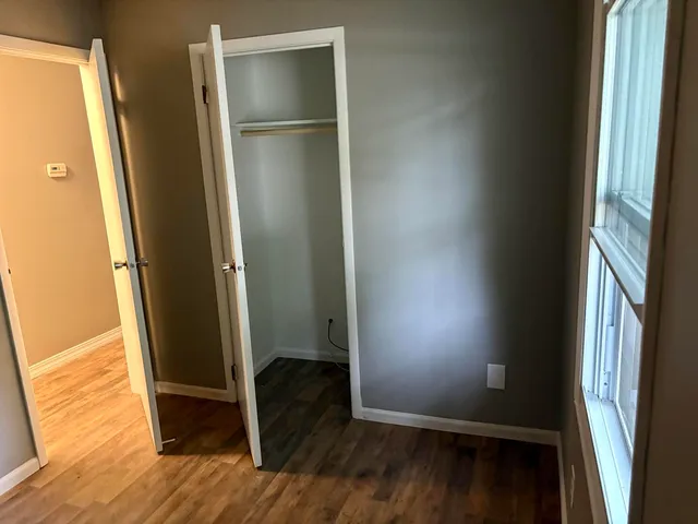 a view of walk in closet with wooden floor
