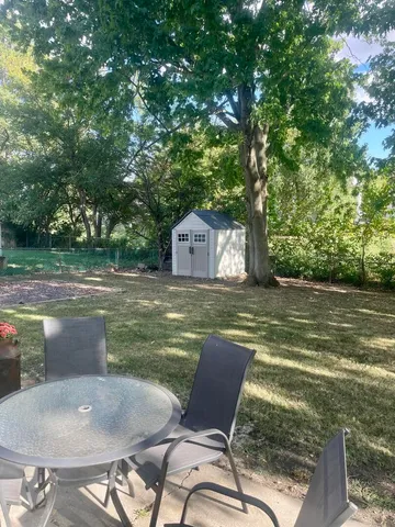 a backyard of a house with table and chairs
