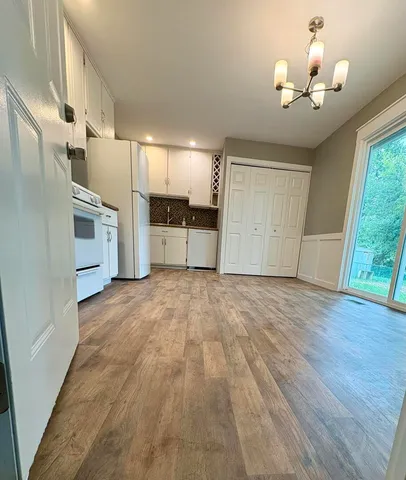 a view of a kitchen with a sink and dishwasher wooden floor
