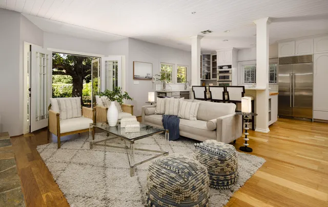 a kitchen with stainless steel appliances granite countertop a table chairs and a refrigerator