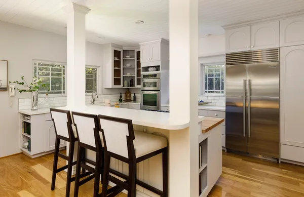 a kitchen with kitchen island a counter top space a sink stainless steel appliances and cabinets