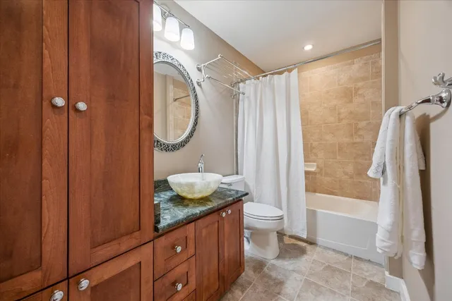 a bathroom with a granite countertop sink toilet and shower