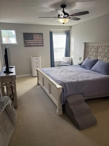 a spacious bedroom with a bed and a chandelier