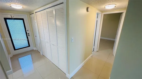 a view of a hallway with wooden floor and entryway