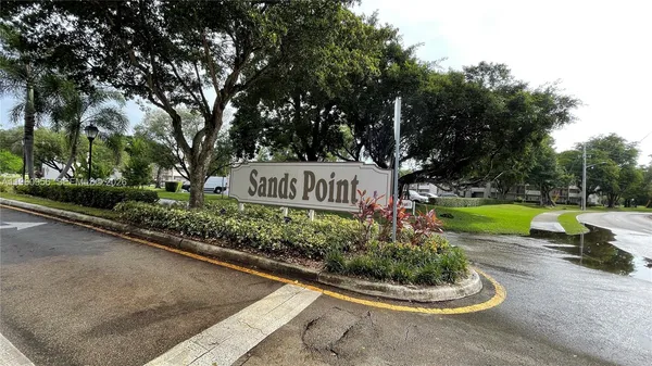 a sign board with a garden and plants