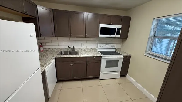 a kitchen with a sink a stove and microwave