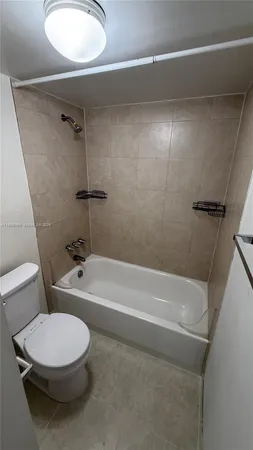 a white toilet sitting next to a bath tub