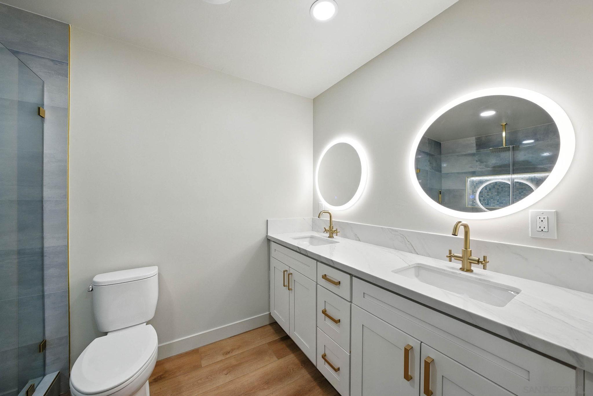 10183 Madrid Way Spring Valley, CA 91977 - Photo 18 of 52 a bathroom with a double vanity sink and a mirror