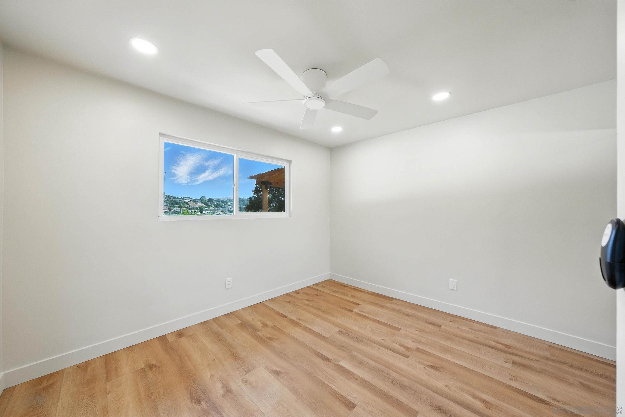 10183 Madrid Way Spring Valley, CA 91977 - Photo 35 of 52 an empty room with wooden floor and windows