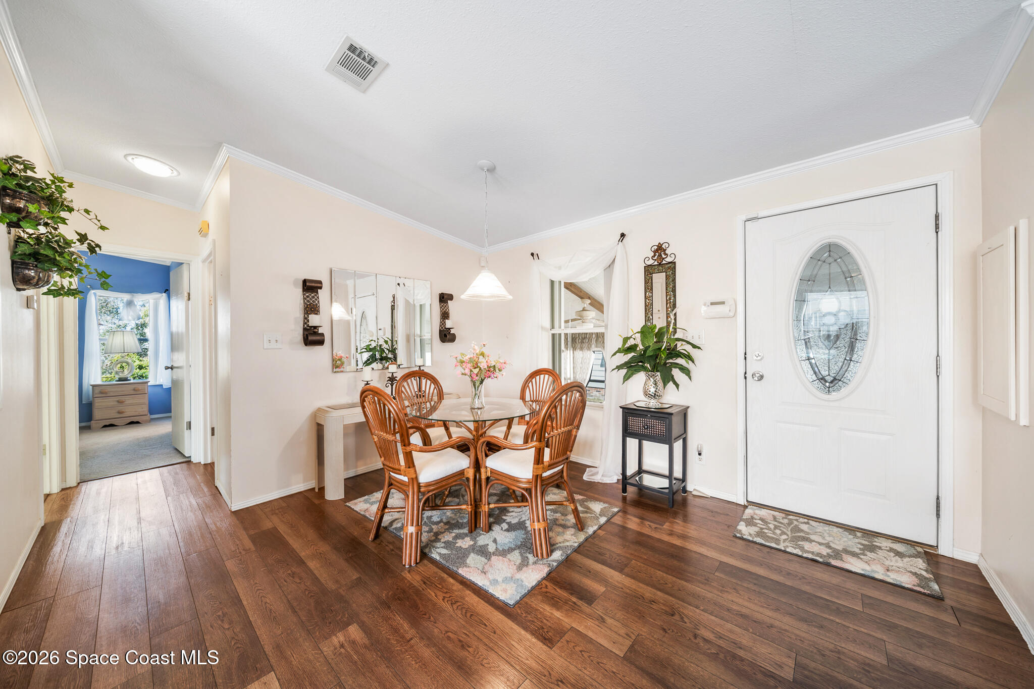 1854 Mango Street Northeast Palm Bay, FL 32905 - Photo 4 of 35 a dining room with furniture potted plants and wooden floor