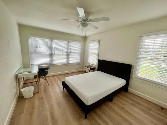 a living room with table chairs and a wooden floor