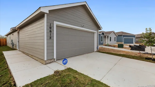 a view of a house with a small yard and wooden fence