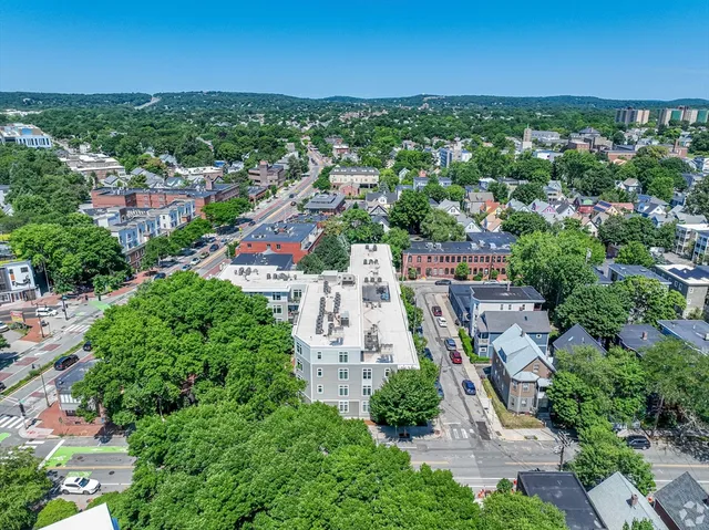 an aerial view of residential houses with outdoor space and trees