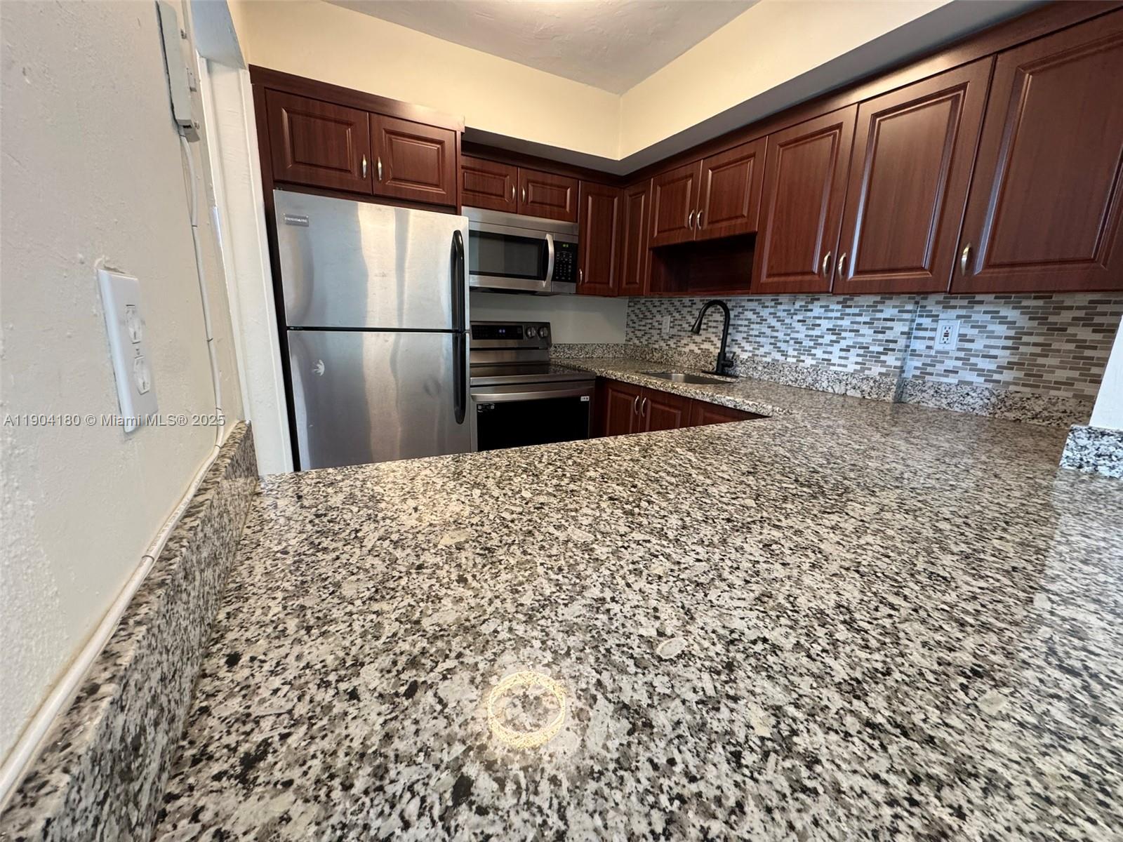2715 Tigertail Avenue, Unit 404 Miami, FL 33133 - Photo 6 of 22 a kitchen with a refrigerator and a sink