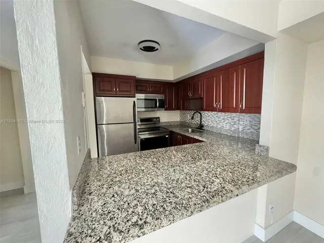 a kitchen with a refrigerator sink and cabinets