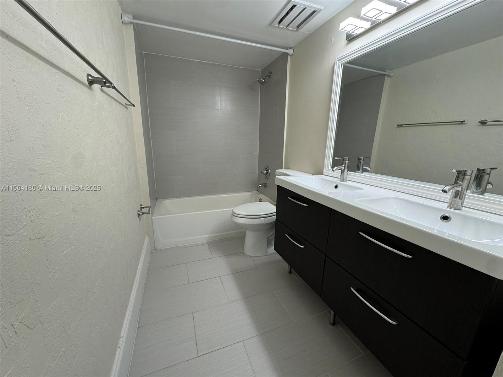 2715 Tigertail Avenue, Unit 404 Miami, FL 33133 - Photo 8 of 22 a bathroom with a double vanity sink toilet and shower