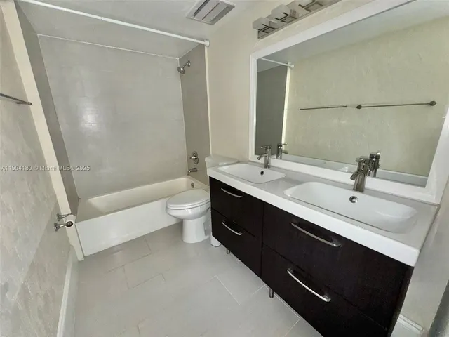 a bathroom with a double vanity sink toilet and shower