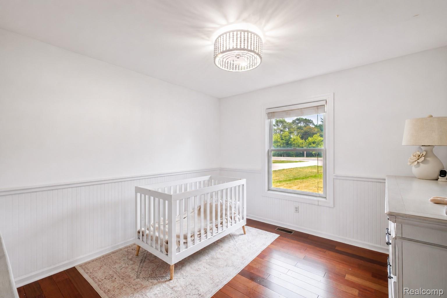 10250 Duffield Road Gaines, MI 48436 - Photo 8 of 28 Hardwood-style flooring, white wainscoting, single-pane window, and a drum-style ceiling fixture