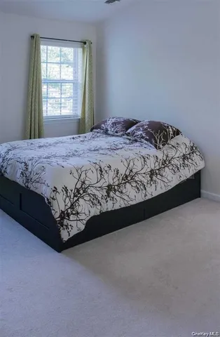 a bed sitting in a bedroom next to a window