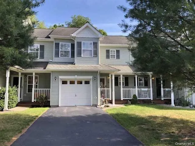 a front view of a house with a yard and trees