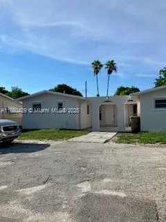 a view of a house with a yard and a large parking space