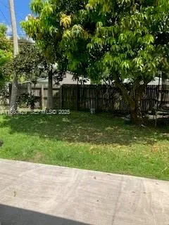 a backyard of a house with plants and large trees
