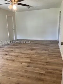 a view of a room with an empty space and wooden floor
